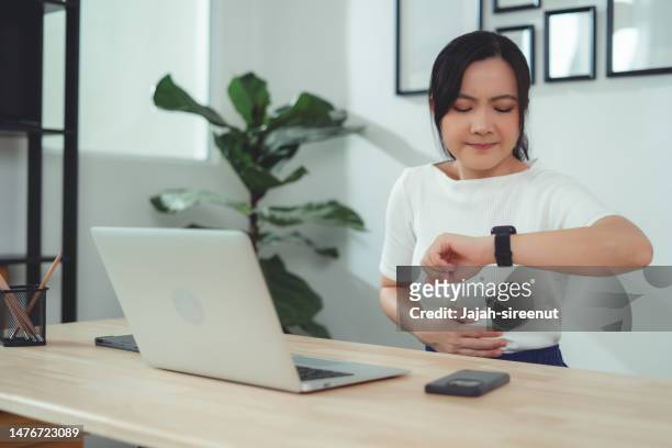 asian woman feeling stomachache sitting at home office. - hungry stock pictures, royalty-free photos & images