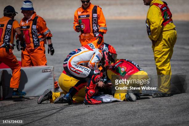 Marc Marquez of Spain and Repsol Honda Team looks at Miguel Oliveira of Portugal and CryptoDATA RNF MotoGP Team after he crashed with him during the...