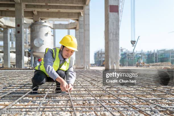 a confident female worker is binding steel bars on a construction site - building block copy space stock pictures, royalty-free photos & images