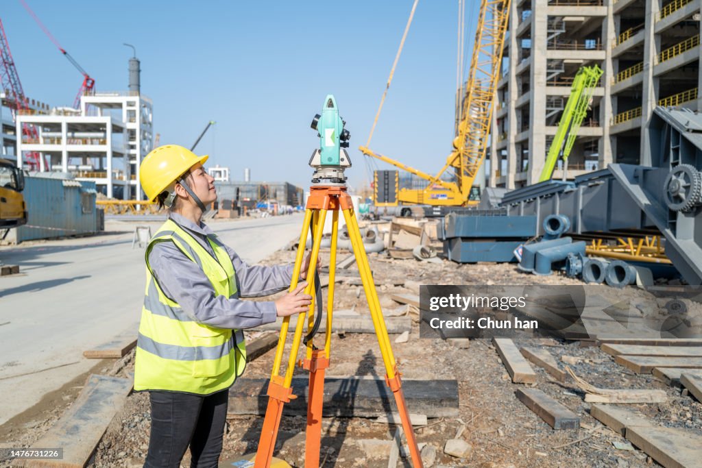 A beautiful female engineer was measuring on the construction site of a chemical factory