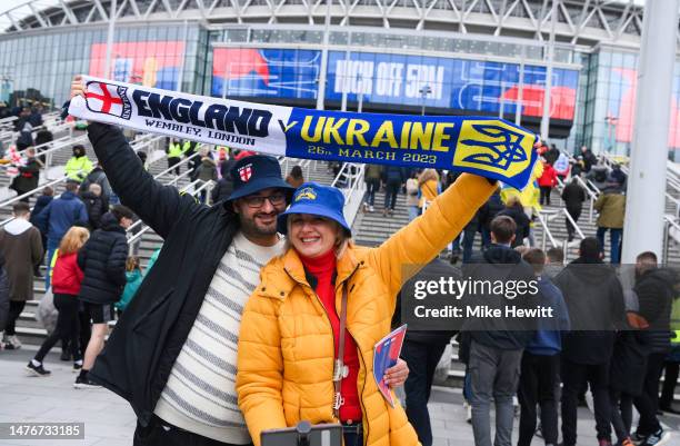 Fans pose for a photo with a half and half scarf outside the stadium prior to during the UEFA EURO 2024 qualifying round group C match between...