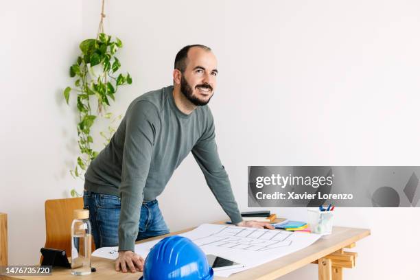 smiling engineer architect designer man with blueprints working on studio - design studio stock pictures, royalty-free photos & images