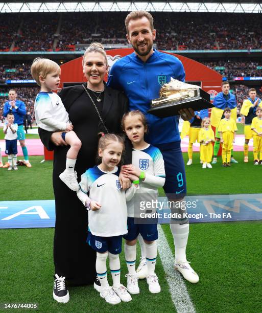 Harry Kane of England poses with their Golden Boot trophy alongside their Wife, Katie Goodland and Children, Ivy Jane Kane, Vivienne Jane Kane and...