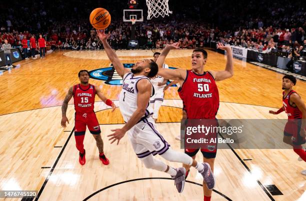 Markquis Nowell of the Kansas State Wildcats shoots the ball against Vladislav Goldin of the Florida Atlantic Owls in the Elite Eight round game of...