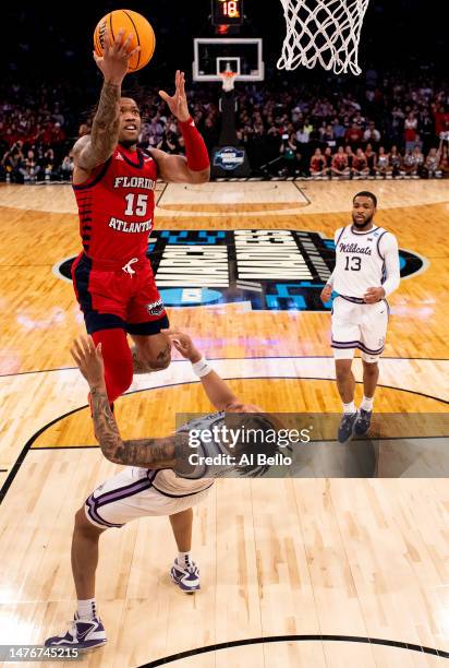 Alijah Martin of the Florida Atlantic Owls shoots the ball as Keyontae Johnson of the Kansas State Wildcats falls to the court during the first half...