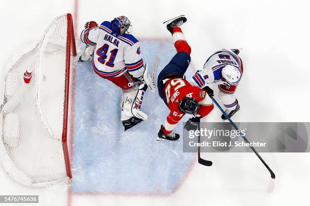 Goaltender Jaroslav Halak of the New York Rangers defends the net with the help of teammate Jacob Trouba against Givani Smith of the Florida Panthers...