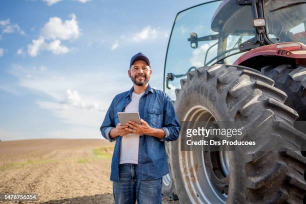 portrait d’agriculteur avec tablette devant son tracteur - champ ferme photos et images de collection