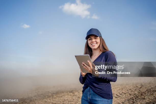 portrait of female farmer with tablet in front of agricultural machine - young agronomist stock pictures, royalty-free photos & images