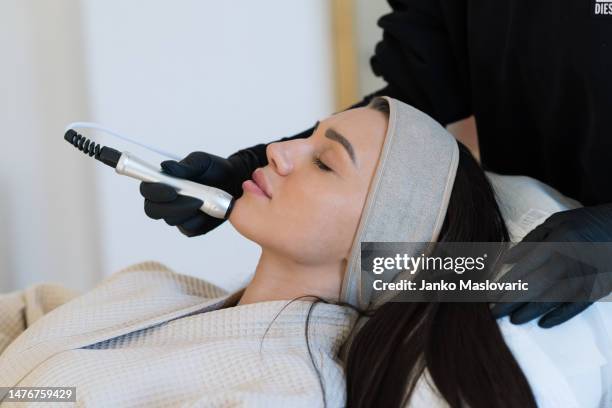 professional female cosmetologist doing hydradermabrasian procedure in cosmetology clinic. stock photo - schoonheidsbehandeling stockfoto's en -beelden