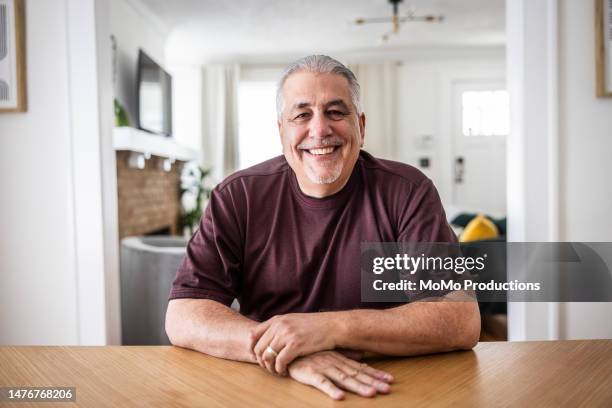 portrait of senior couple in dining room - sitting at table looking at camera stock-fotos und bilder