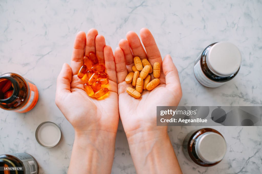 Frau mit Vitaminpillen in den Handflächen