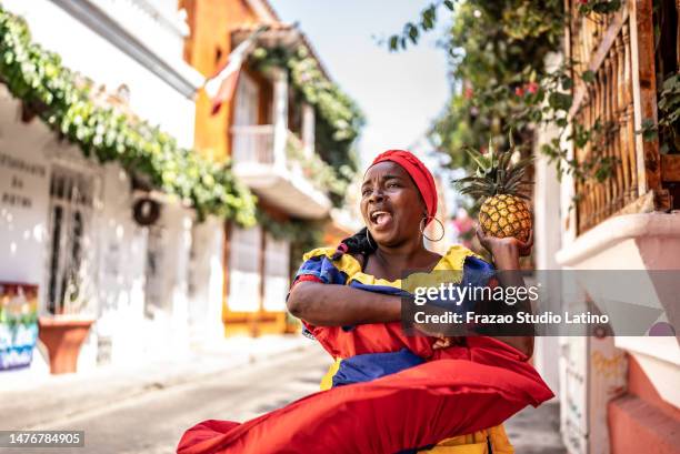 palenquera cammina e balla per strada a cartagena, colombia - cultura colombiana foto e immagini stock