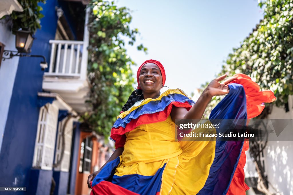 Palenquera caminando y bailando en la calle en Cartagena, Colombia