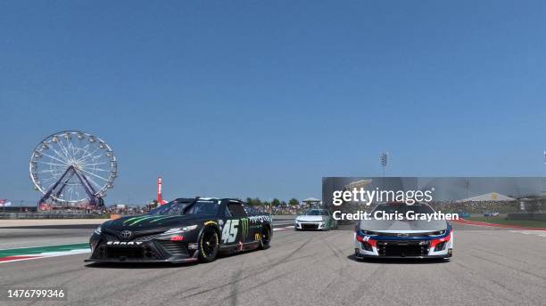 William Byron, driver of the Liberty University Chevrolet, and Tyler Reddick, driver of the Monster Energy Toyota, lead the field on a pace lap prior...