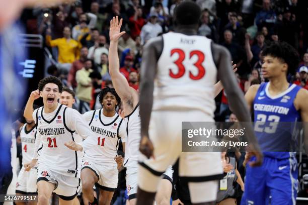 Miles Byrd, Demarshay Johnson Jr. #11 and Elijah Saunders of the San Diego State Aztecs run to Aguek Arop to celebrate defeating the Creighton...