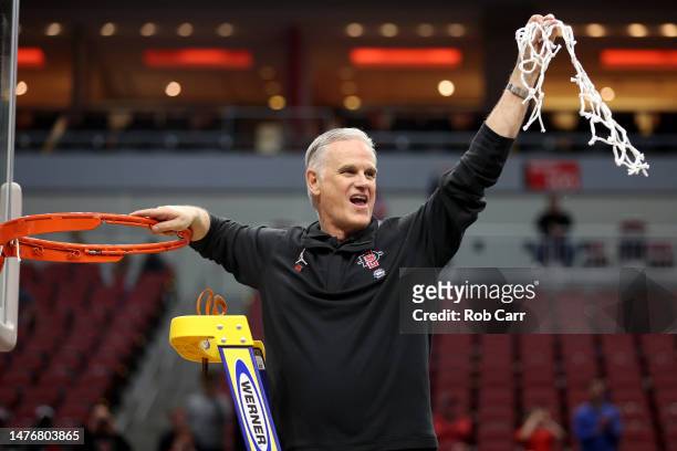 Head coach Brian Dutcher of the San Diego State Aztecs celebrates by cutting down the net after defeating the Creighton Bluejays in the Elite Eight...
