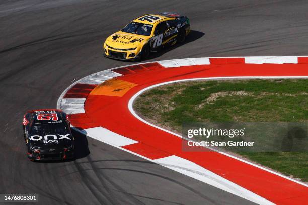 Kimi Raikkonen, driver of the Onx Homes/iLOQ Chevrolet, and Josh Bilicki, driver of the Zeigler Auto Group Chevrolet, race during the NASCAR Cup...