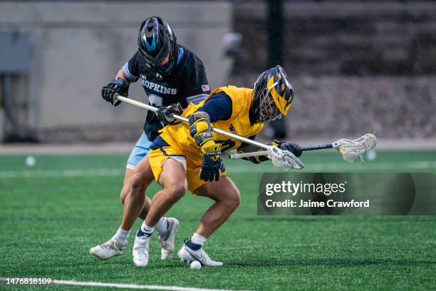 Ryan Cohen of the Michigan Wolverines fights for a ground ball against Alex Mazzone of Johns Hopkins during the 2nd quarter at U-M Lacrosse Stadium...