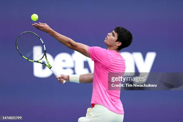 Carlos Alcaraz of Spain serves to Dusan Lajovic of Serbia during the Miami Open at Hard Rock Stadium on March 26, 2023 in Miami Gardens, Florida.