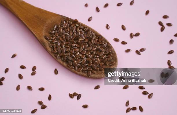 flax seed in spoon on pink background. healthy food. - leinsamen stock-fotos und bilder