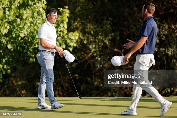 Rory McIlroy of Northern Ireland and Scottie Scheffler of the United States shake hands on the 17th green after McIlroy won their match 2 & 1 during...