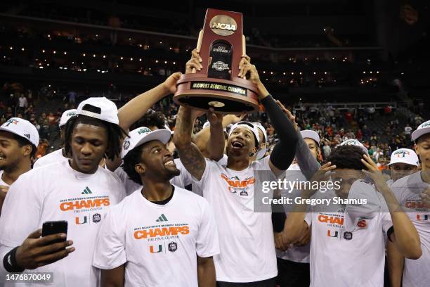 The Miami Hurricanes hoist the trophy after defeating the Texas Longhorns 88-81 in the Elite Eight round of the NCAA Men's Basketball Tournament at...