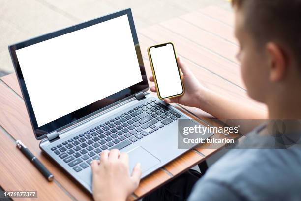 teenager mit laptop und telefon draußen. blank-screen-konzept. - twitter template stock-fotos und bilder