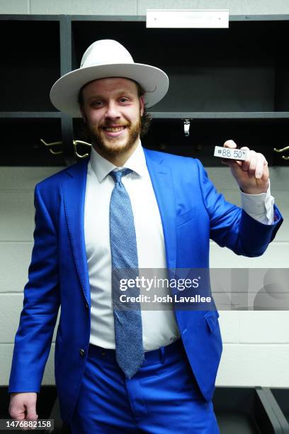 David Pastrnak of the Boston Bruins poses with the puck after scoring his 50th goal of the season against the Carolina Hurricanes at PNC Arena on...