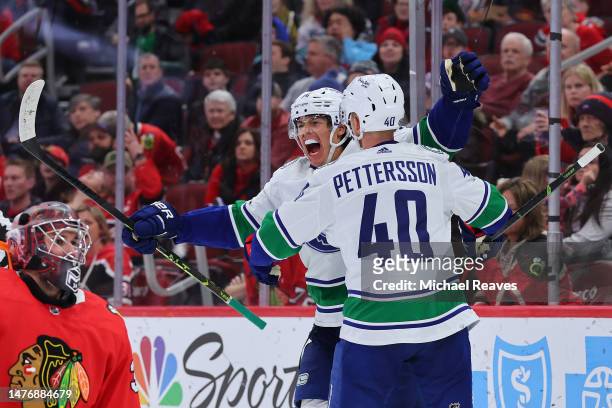Ethan Bear and Elias Pettersson of the Vancouver Canucks celebrate a goal against the Chicago Blackhawks during the third period at United Center on...