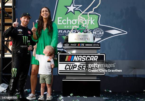 Tyler Reddick, driver of the Monster Energy Toyota, celebrates with his wife Alexa, and son Beau in victory lane after winning the NASCAR Cup Series...