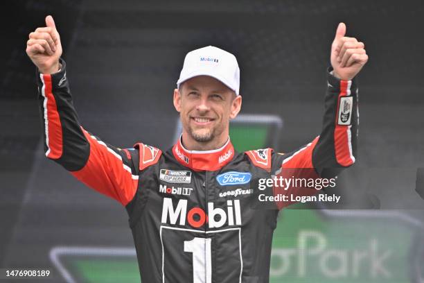 Jenson Button, driver of the Mobil 1 Ford, gives a thumbs up to fans as he walks onstage during driver intros prior to the NASCAR Cup Series EchoPark...