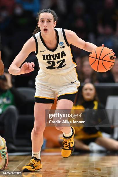 Caitlin Clark of the Iowa Hawkeyes dribbles the ball against the Louisville Cardinals during the third quarter in the Elite Eight round of the NCAA...