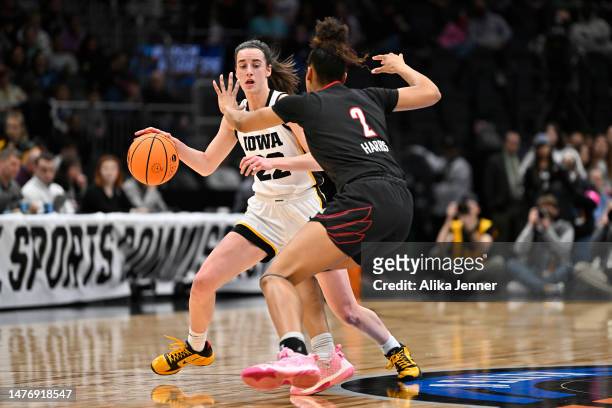 Caitlin Clark of the Iowa Hawkeyes dribbles the ball against Nyla Harris of the Louisville Cardinals during the third quarter in the Elite Eight...