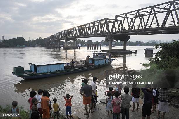 In this photograph taken on June 4, 2012 a crowd of Indonesian residents send off a wooden boat transporting a toothless crocodile named "Hollande",...