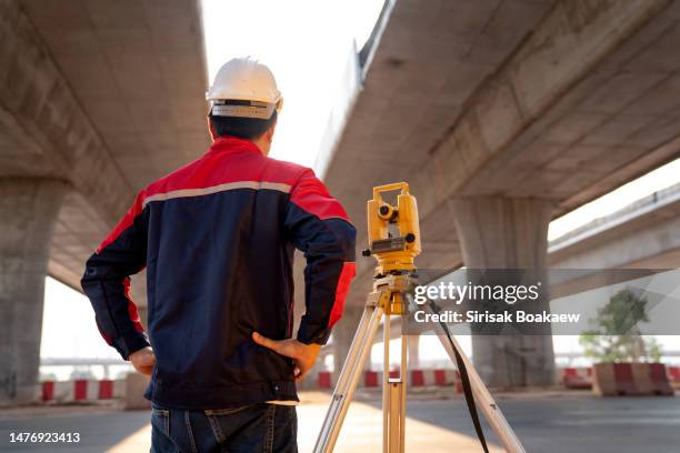 male civil engineer surveying with theodolite apparatus before construction - land surveyor stock pictures, royalty-free photos & images