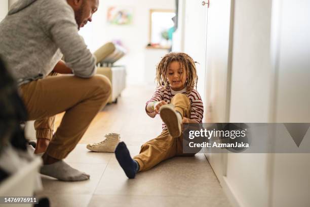 padre e hijo poniéndose los zapatos en casa - vestirse fotografías e imágenes de stock