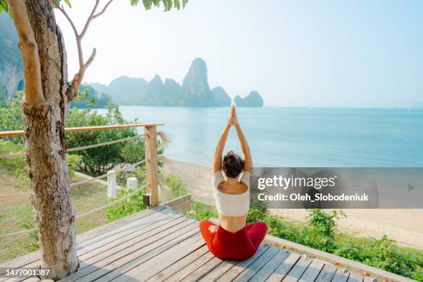 femme assise en lotus pose avec les mains en l’air sur le fond de la mer - kundalini photos et images de collection