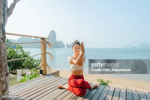 frau beim yoga am strand in krabi - voyage zen stock-fotos und bilder