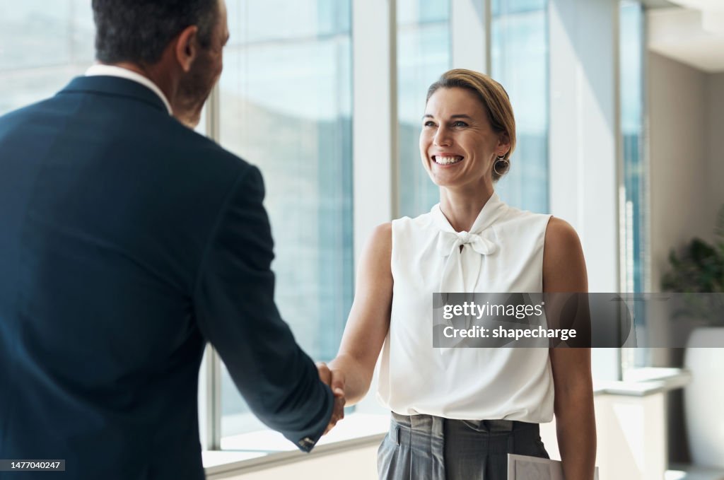 Stretta di mano, incontro e partnership con uomini d'affari per la collaborazione b2b, l'accoglienza onboarding o l'opportunità professionale. Donna aziendale o clienti stringono la mano per l'intervista sull'affare nell'edificio degli uffici