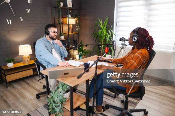 black woman and caucasian man together hosting a podcast show - radio host stock pictures, royalty-free photos & images