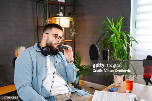 man smokes an electronic cigarette during a break in the studio - radio host stock pictures, royalty-free photos & images