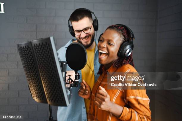 couple enregistrant dans un studio de musique et portant des écouteurs - animateur radio photos et images de collection