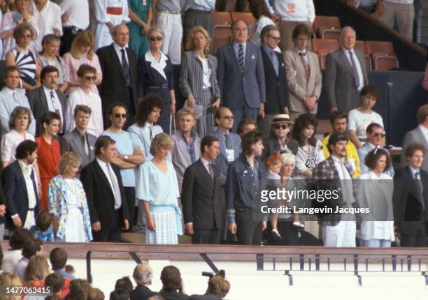 Princess Diana and Prince Charles wave from the crowd during the Live Aid concert held in London. The 1985 concert was held simultaneously at JFK...