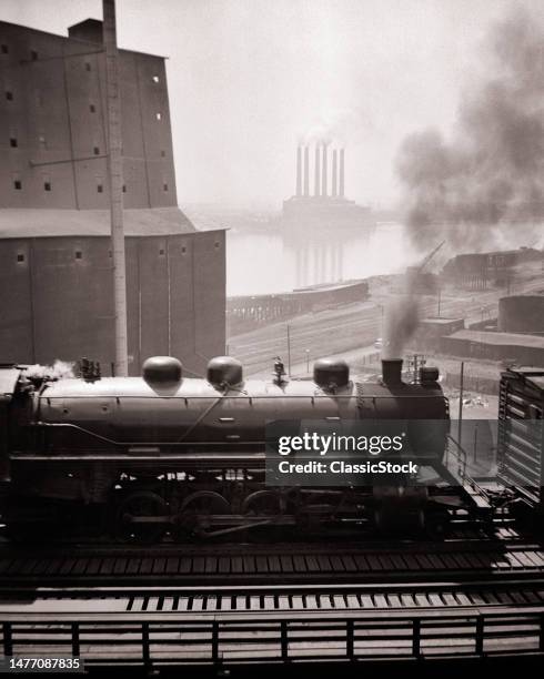 1930s steam train by grain elevator mississippi River Cahokia il power plant from the municipal bridge St Louis Missouri USA.