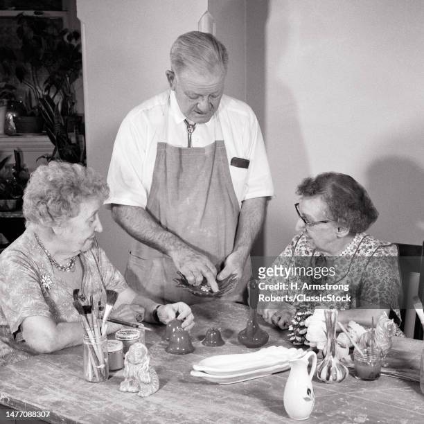 1960s senior adults in pottery painting class session.