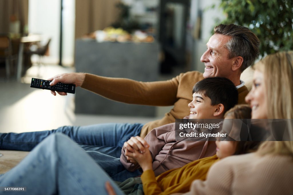 Glückliche Familie, die zu Hause fernsieht.