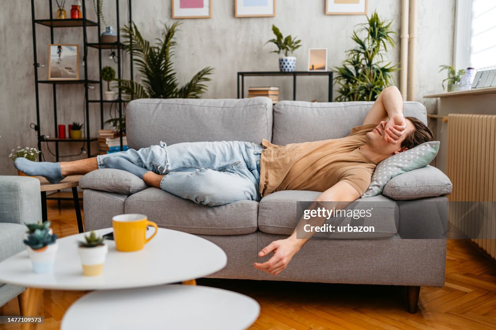 Young Man Sleeping On The Sofa At Home