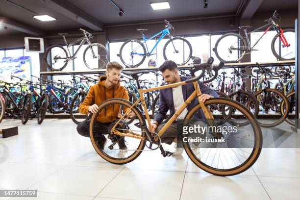 salesman and male customer in bicycle shop - product life cycle stock pictures, royalty-free photos & images