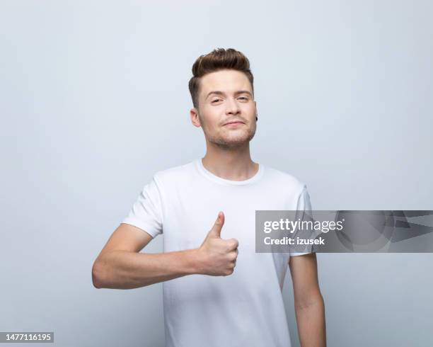 portrait of young man with thumb up - man white t shirt stock pictures, royalty-free photos & images