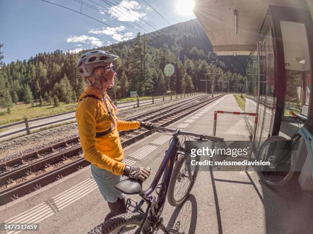 mountain biker waiting for train at the station - engadin stock pictures, royalty-free photos & images